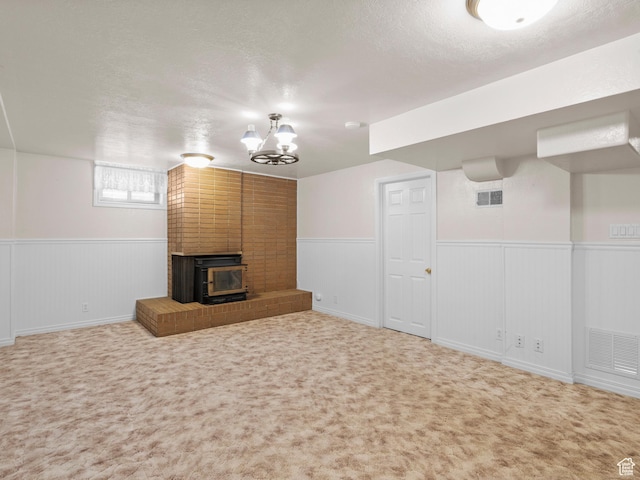 9751 S Garnet Dr, Sandy, UT 84094 - below grade area featuring a wood stove, a wainscoted wall, a textured ceiling, carpet floors, and a chandelier