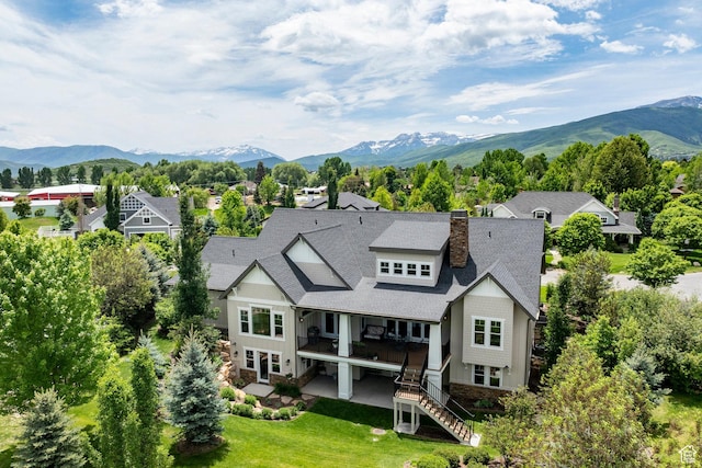 1123 Dutch Fields Pkwy, Midway, UT 84049 - rear view of house with stairs, a shingled roof, a chimney, a mountain view, and a lawn