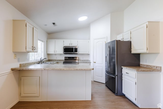 710 S Indian Hills Dr # 64, St George, UT 84770 - kitchen featuring appliances with stainless steel finishes, a sink, vaulted ceiling, a peninsula, and light wood-type flooring