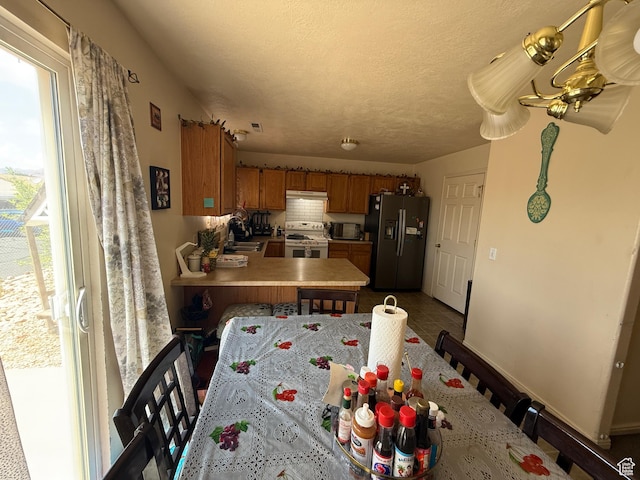 1087 N 1800th Cir W, St George, UT 84770 - kitchen with stainless steel refrigerator with ice dispenser, white electric range, a sink, brown cabinetry, and black microwave