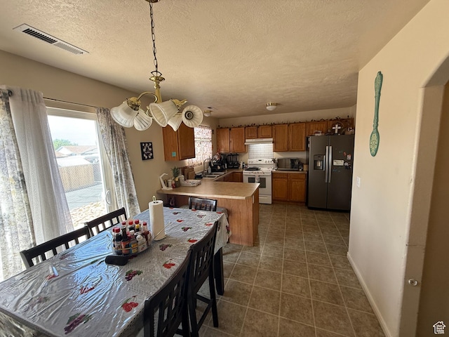 1087 N 1800th Cir W, St George, UT 84770 - dining area featuring a chandelier, a textured ceiling, dark tile patterned flooring, and baseboards