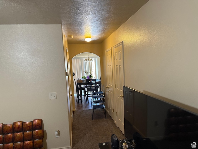 1087 N 1800th Cir W, St George, UT 84770 - hall featuring arched walkways, dark carpet, a textured ceiling, a chandelier, and baseboards
