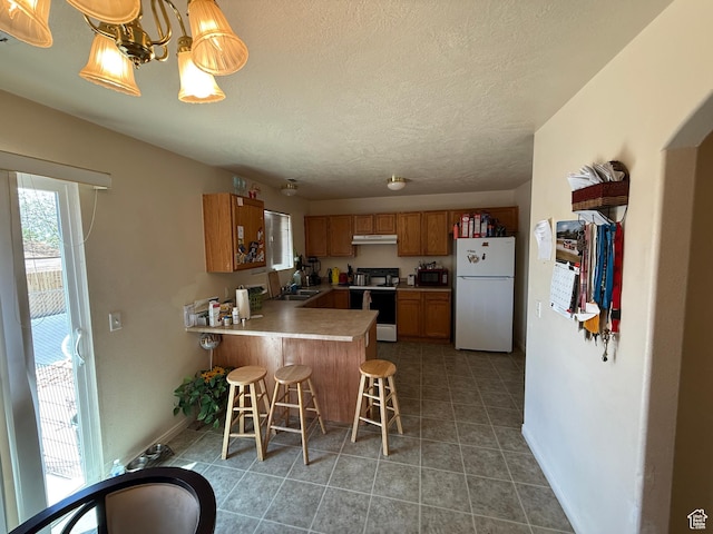 1087 N 1800th Cir W, St George, UT 84770 - kitchen with white appliances, a sink, a peninsula, brown cabinetry, and a chandelier