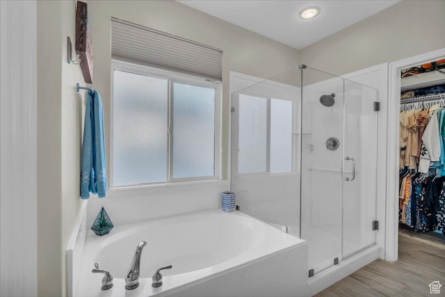 1646 W Sunkissed Dr, St George, UT 84790 - bathroom featuring a stall shower, a spacious closet, a bath, and wood finished floors