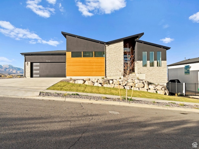 7272 W Summit Crest Cir, Herriman, UT 84096 - contemporary home featuring stone siding, driveway, a garage, and a mountain view