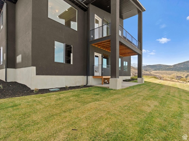 7272 W Summit Crest Cir, Herriman, UT 84096 - view of side of home with stucco siding, a mountain view, a lawn, and a balcony