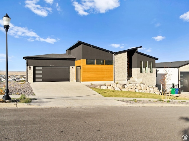 7272 W Summit Crest Cir, Herriman, UT 84096 - contemporary house featuring an attached garage, driveway, stucco siding, and stone siding