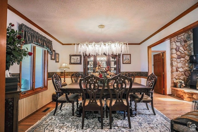 580 S Stagecoach Dr, Brookside, UT 84782 - dining space featuring a chandelier, wood finished floors, wainscoting, a textured ceiling, and crown molding