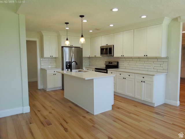919 E Millbrook Way, Bountiful, UT 84010 - kitchen featuring appliances with stainless steel finishes, baseboards, light wood-type flooring, tasteful backsplash, and white cabinets