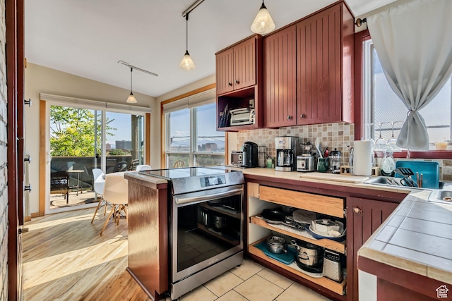 319 N Almond St W # Rear, Salt Lake City, UT 84103 - kitchen featuring stainless steel electric range oven, tile counters, vaulted ceiling, hanging light fixtures, and backsplash