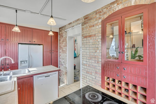 319 N Almond St W # Rear, Salt Lake City, UT 84103 - kitchen featuring dishwashing machine, white fridge with ice dispenser, brick wall, light tile patterned floors, and tile countertops