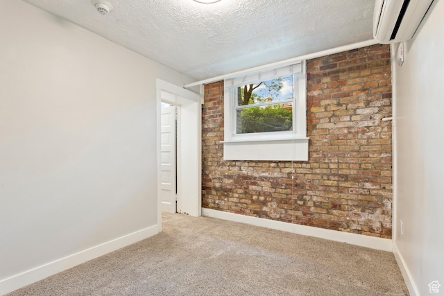 86 B St E Unit 24, Salt Lake City, UT 84150 - carpeted empty room featuring a wall mounted AC, a textured ceiling, a smoke detector, baseboards, and brick wall
