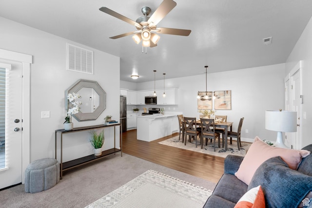 1809 W Terra Vista Ln N Unit B1, Saratoga Springs, UT 84045 - carpeted living area with ceiling fan, wood finished floors, and baseboards