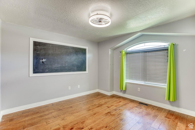 2155 N 170 W, Tooele, UT 84074 - empty room with hardwood / wood-style flooring, a textured ceiling, baseboards, and lofted ceiling