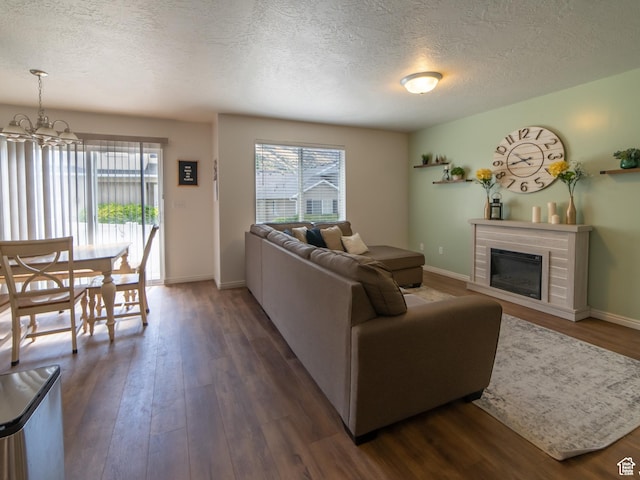 1305 S 1410 E, Provo, UT 84606 - living area featuring dark wood-type flooring, healthy amount of natural light, a textured ceiling, a glass covered fireplace, and baseboards