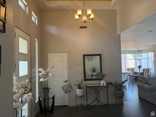 410 N 2720 E, St George, UT 84790 - foyer entrance featuring a chandelier, a high ceiling, finished concrete floors, and baseboards