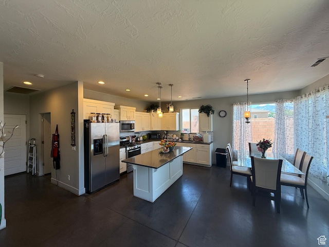 410 N 2720 E, St George, UT 84790 - kitchen with stainless steel appliances, dark countertops, white cabinetry, baseboards, and a textured ceiling