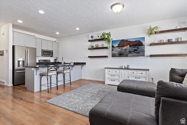 1252 W Cinch Way S, Bluffdale, UT 84065 - living room featuring recessed lighting, wood finished floors, baseboards, and a textured ceiling