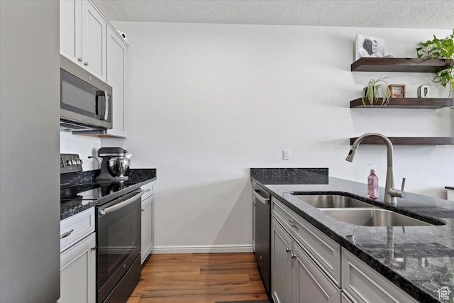 1252 W Cinch Way S, Bluffdale, UT 84065 - kitchen with appliances with stainless steel finishes, a sink, open shelves, dark stone countertops, and a textured ceiling