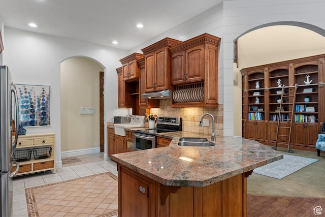 8149 S 2425 E, South Weber, UT 84405 - kitchen with stainless steel appliances, under cabinet range hood, a peninsula, arched walkways, and a kitchen bar