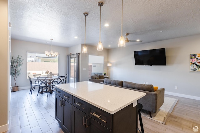 266 N 2020 W # 74, Hurricane, UT 84737 - kitchen featuring baseboards, a textured ceiling, open floor plan, a center island, and recessed lighting
