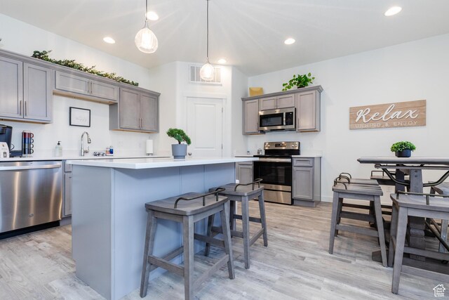 356 W Oregon Trail Dr Unit 100, Garden City, UT 84028 - kitchen featuring stainless steel appliances, light wood finished floors, light countertops, a kitchen island, and recessed lighting