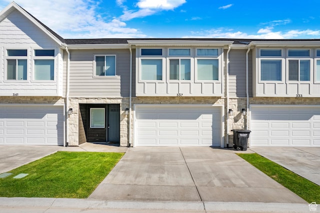 356 W Oregon Trail Dr Unit 100, Garden City, UT 84028 - townhome / multi-family property with concrete driveway, a garage, stone siding, and board and batten siding