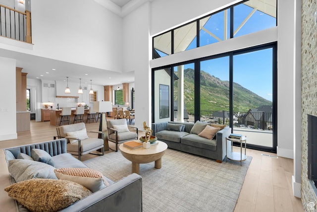 3851 W Box Elder Cir, Alpine, UT 84004 - living area with a mountain view, light wood-style floors, healthy amount of natural light, a high ceiling, and baseboards