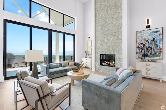 3851 W Box Elder Cir, Alpine, UT 84004 - living area with a high ceiling, light wood-type flooring, a fireplace, baseboards, and a water view