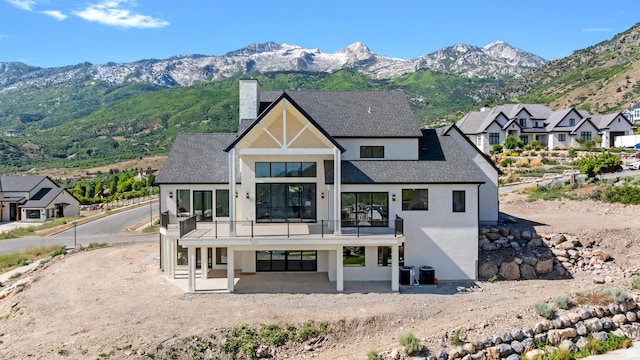 3851 W Box Elder Cir, Alpine, UT 84004 - back of property featuring a balcony, stucco siding, a chimney, and a mountain view
