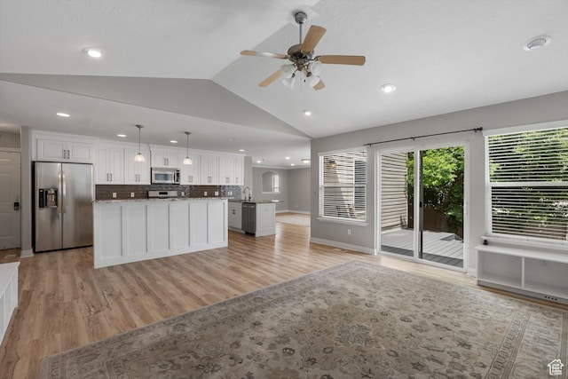 1754 E Cedar Trails Way, Eagle Mountain, UT 84005 - kitchen featuring stainless steel appliances, open floor plan, a center island, vaulted ceiling, and white cabinetry