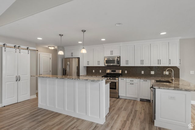 1754 E Cedar Trails Way, Eagle Mountain, UT 84005 - kitchen featuring stainless steel appliances, white cabinets, a sink, light wood-style floors, and backsplash