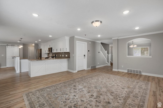 1754 E Cedar Trails Way, Eagle Mountain, UT 84005 - unfurnished living room featuring baseboards, crown molding, light wood-style floors, stairs, and recessed lighting