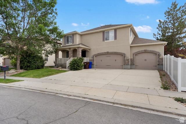 1754 E Cedar Trails Way, Eagle Mountain, UT 84005 - traditional home with stucco siding, concrete driveway, a porch, stone siding, and an attached garage