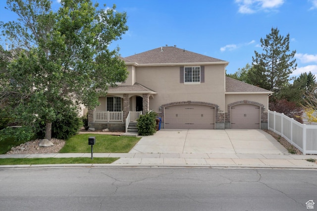 1754 E Cedar Trails Way, Eagle Mountain, UT 84005 - traditional-style house with stucco siding, concrete driveway, covered porch, and an attached garage