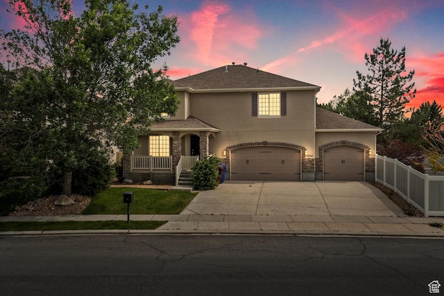 1754 E Cedar Trails Way, Eagle Mountain, UT 84005 - view of front of home featuring stucco siding, driveway, a porch, stone siding, and a garage
