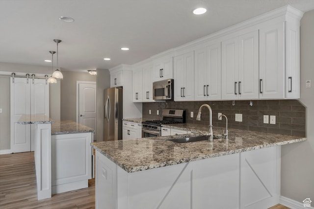 1754 E Cedar Trails Way, Eagle Mountain, UT 84005 - kitchen with stainless steel appliances, a sink, light wood-style floors, baseboards, and decorative backsplash