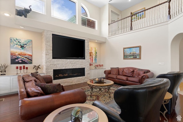 4715 S 1500 E, Ogden, UT 84403 - living room featuring a towering ceiling, wood finished floors, a fireplace, arched walkways, and recessed lighting