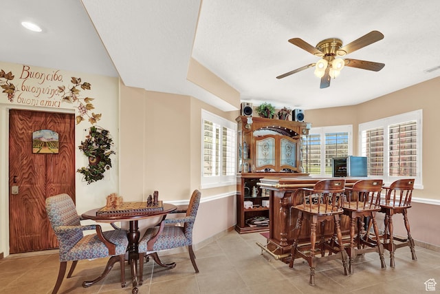 4715 S 1500 E, Ogden, UT 84403 - dining space with a dry bar, ceiling fan, baseboards, light tile patterned floors, and a textured ceiling