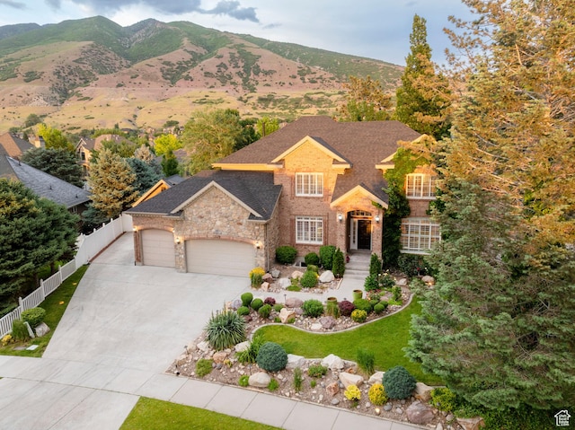 13279 S Berry Ln, Draper, UT 84020 - view of front of home featuring a garage, driveway, stone siding, a mountain view, and roof with shingles