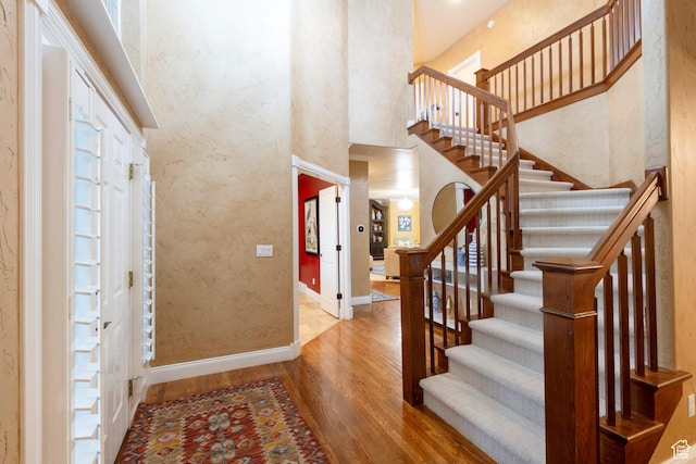 13279 S Berry Ln, Draper, UT 84020 - foyer entrance with wood finished floors, a towering ceiling, baseboards, and stairs