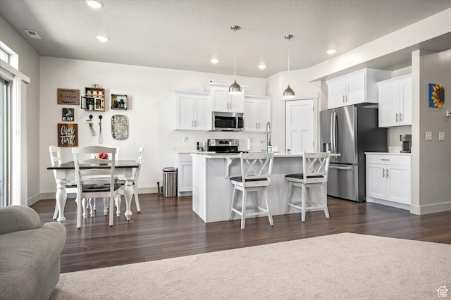 4488 S Haven Creek Rd W Unit 25D, West Haven, UT 84401 - kitchen featuring appliances with stainless steel finishes, a breakfast bar area, white cabinets, dark wood-style floors, and recessed lighting