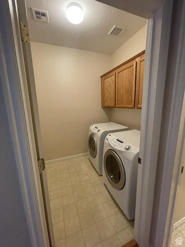 3400 E Hidden Springs Dr, Washington, UT 84780 - laundry room with washing machine and dryer, cabinet space, a textured ceiling, light floors, and baseboards