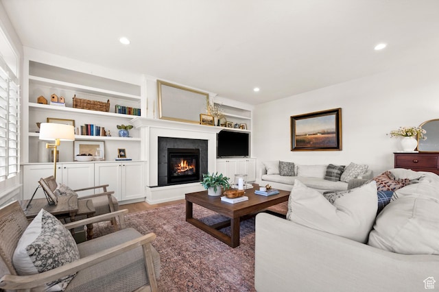 12387 Timberline Dr Unit 53, Highland, UT 84003 - living room featuring a glass covered fireplace, wood finished floors, recessed lighting, and built in shelves