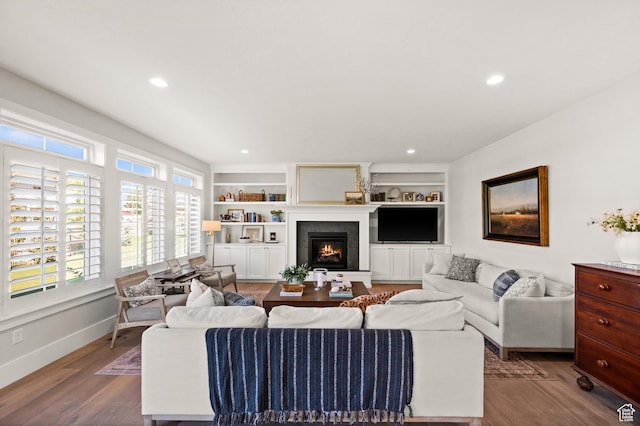 12387 Timberline Dr Unit 53, Highland, UT 84003 - living room featuring wood finished floors, a lit fireplace, recessed lighting, built in shelves, and baseboards