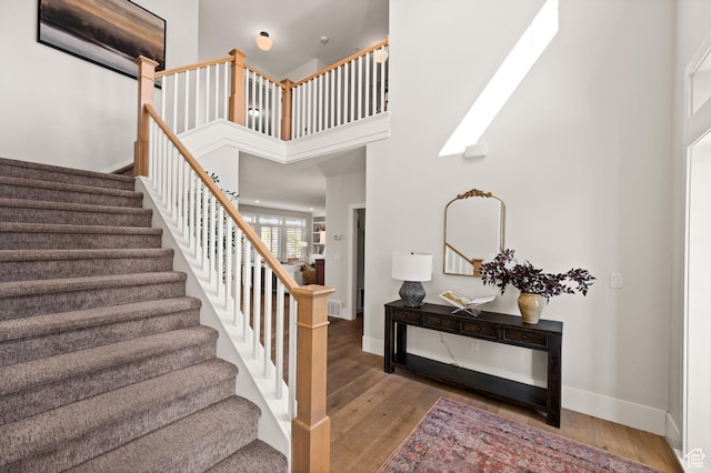 12387 Timberline Dr Unit 53, Highland, UT 84003 - stairs featuring wood finished floors, baseboards, and a towering ceiling