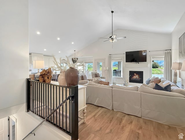 1852 N 4100 W, Plain City, UT 84404 - living area with ceiling fan, high vaulted ceiling, light wood-type flooring, a glass covered fireplace, and recessed lighting