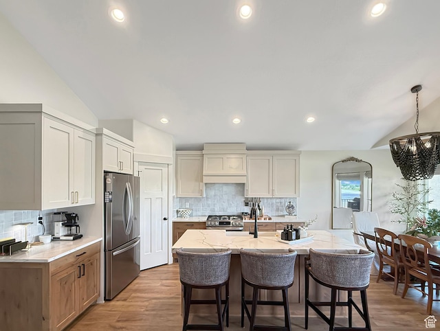 1852 N 4100 W, Plain City, UT 84404 - kitchen featuring stainless steel appliances, lofted ceiling, a chandelier, a kitchen breakfast bar, and backsplash