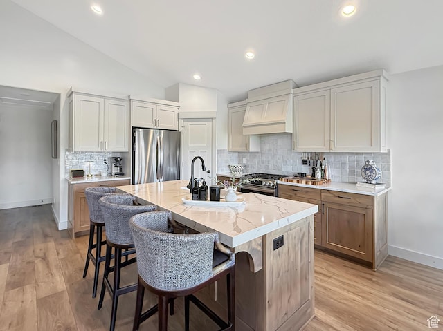 1852 N 4100 W, Plain City, UT 84404 - kitchen featuring stainless steel appliances, custom range hood, baseboards, light stone counters, and light wood-style flooring