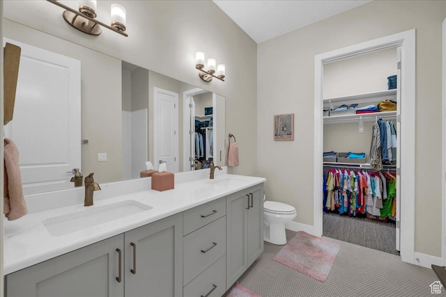 1210 W Ledgerwood Dr, St George, UT 84790 - full bathroom with double vanity, toilet, a spacious closet, and baseboards